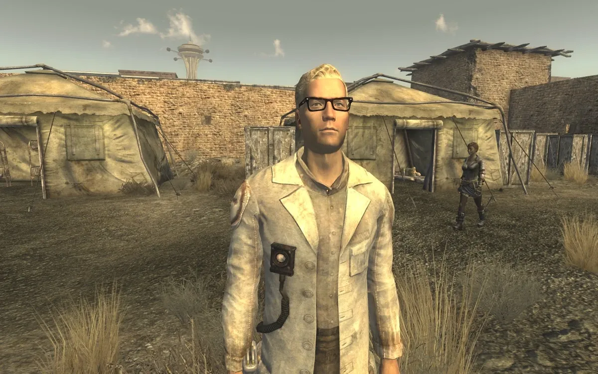 Arcade Gannon con su bata de médico ante las tiendas del Old Mormon Fort de Freeside en Fallout: New Vegas