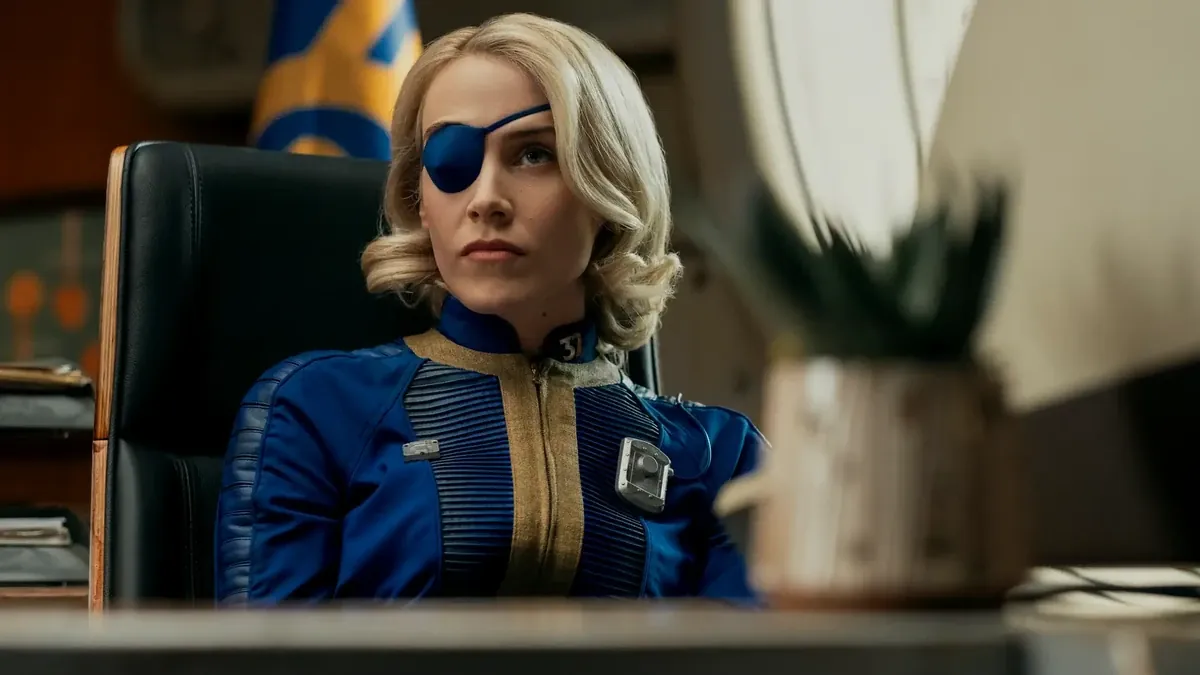 Steph Harper con el parche en el ojo y el mono azul del refugio en un despacho de la serie de Fallout