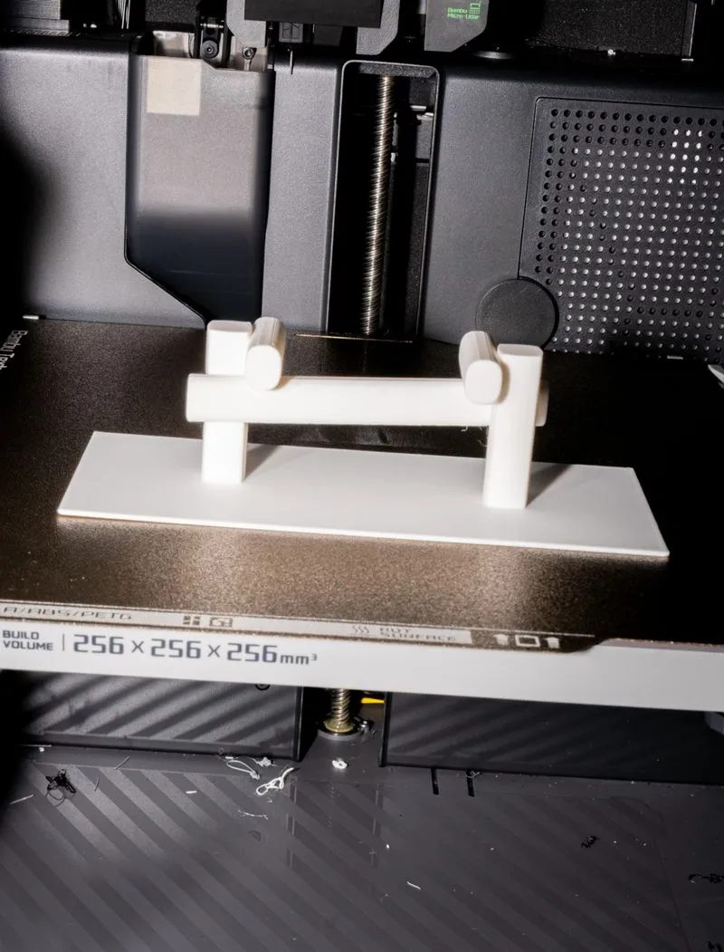White 3D-printed object on the build plate of a 3D printer with 256 x 256 x 256 mm build volume.