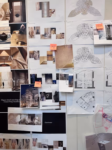 Wall covered with architectural plans, design photos, and notes including sketches, floor plans, and mood board images.