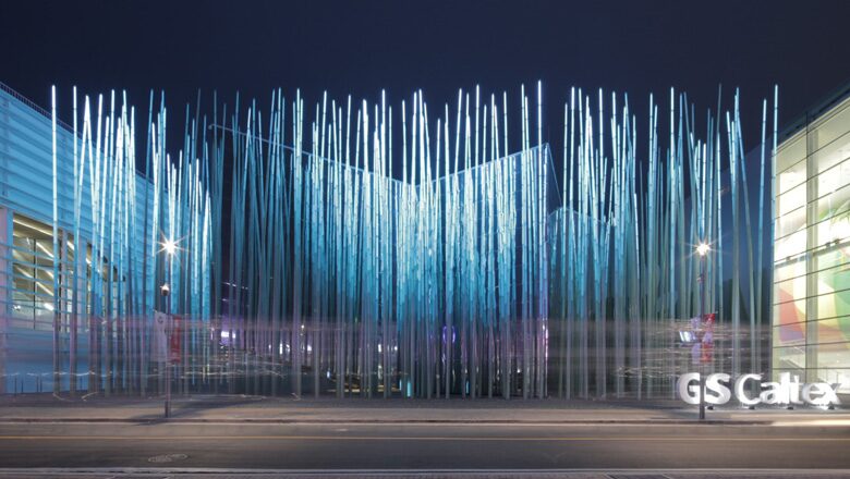Modern glass and steel building entrance with vertical ribbed facade at night