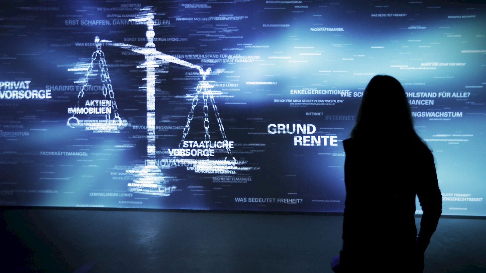 Silhouetted figure viewing digital screen displaying German social welfare and pension information