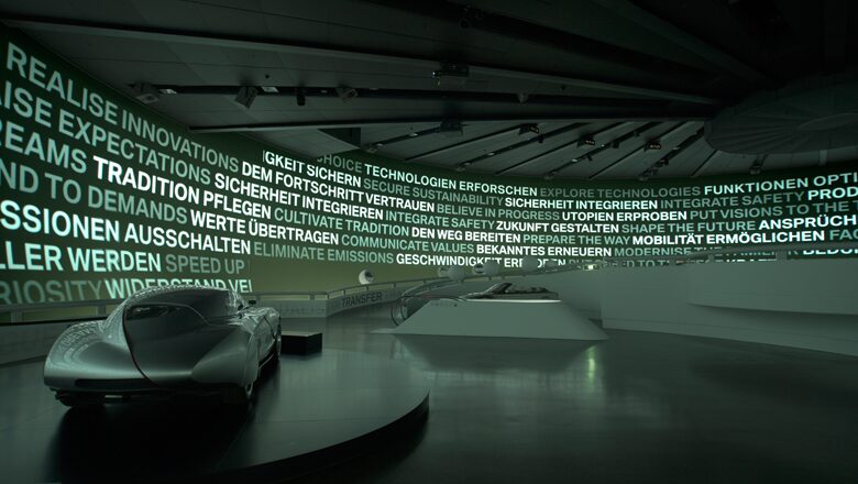 Futuristic concept cars displayed in modern exhibition space with illuminated text walls.