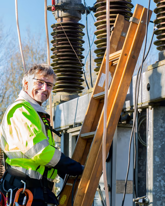 electrician on ladder climbing an electrical circuit breaker