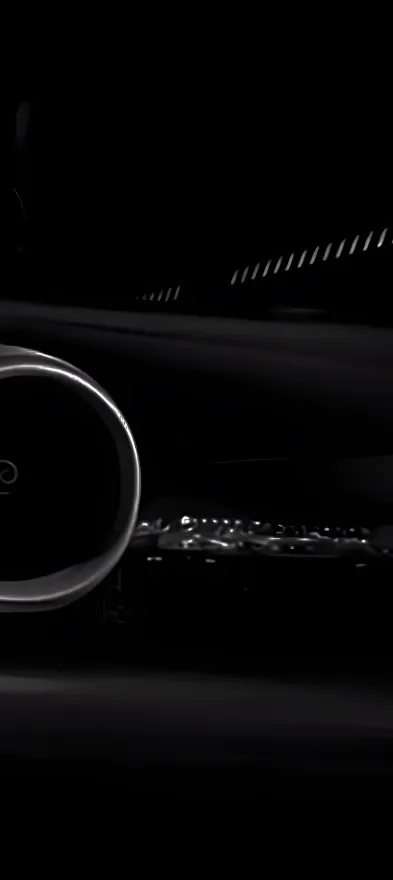 Close-up of a car turbine or air intake vent with metallic detailing in low light.