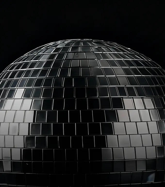 Close-up of a reflective disco ball with small square mirrors against a black background.