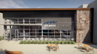 Modern building facade with 'Atlantic Packaging Solution Center' logo above large glass doors and outdoor seating area.