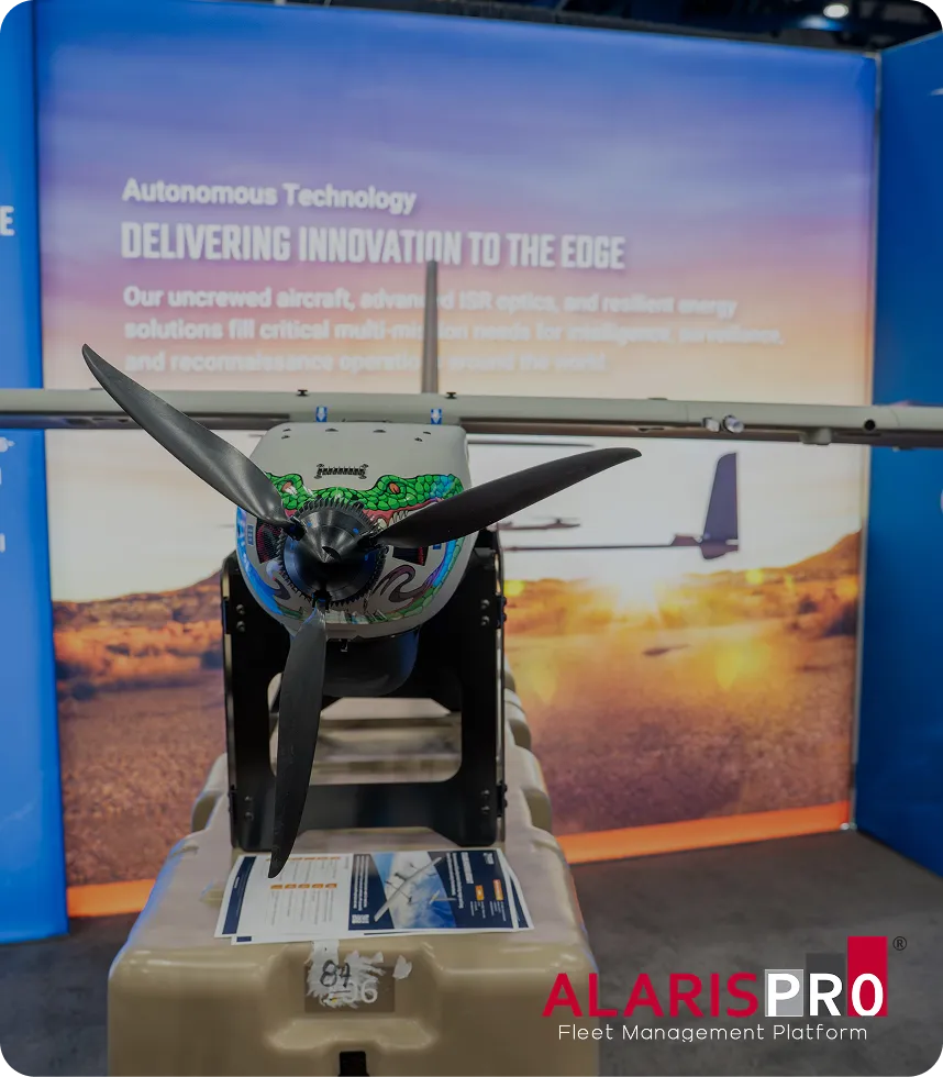 AlarisPro | Front view of a small unmanned aircraft with a three-blade propeller, displayed in front of a backdrop about autonomous technology and innovation.