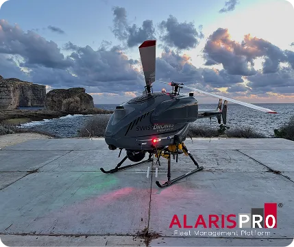 Alaris Pro | SwissDrones unmanned helicopter drone on concrete platform near rocky coastline at sunset.