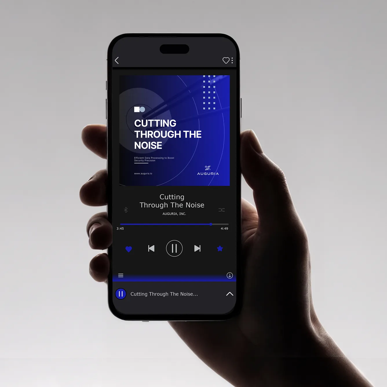 Hand holding a smartphone displaying a music player app playing 'Cutting Through The Noise' by Auguria, Inc.