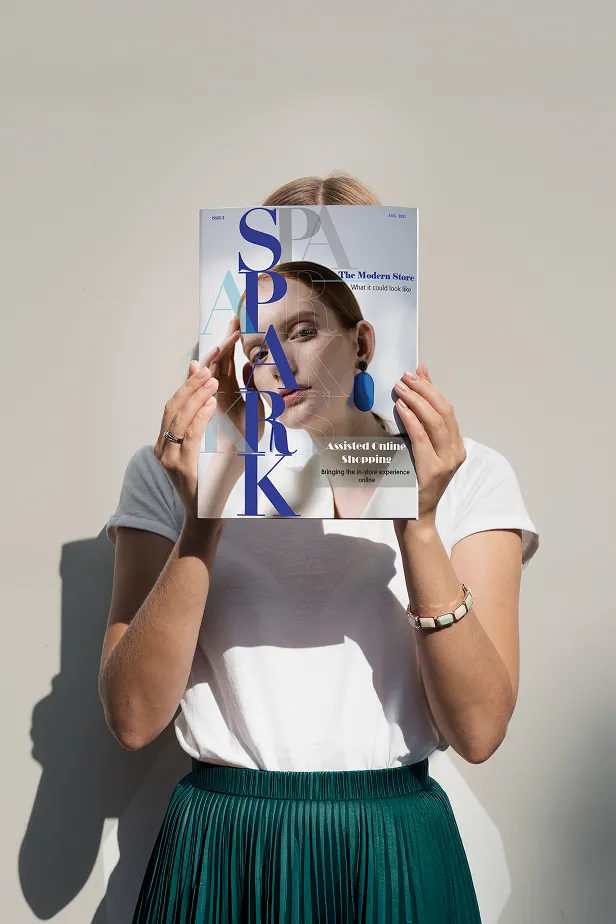 Person holding a magazine titled 'SPARK' with their face visible through the magazine cover.