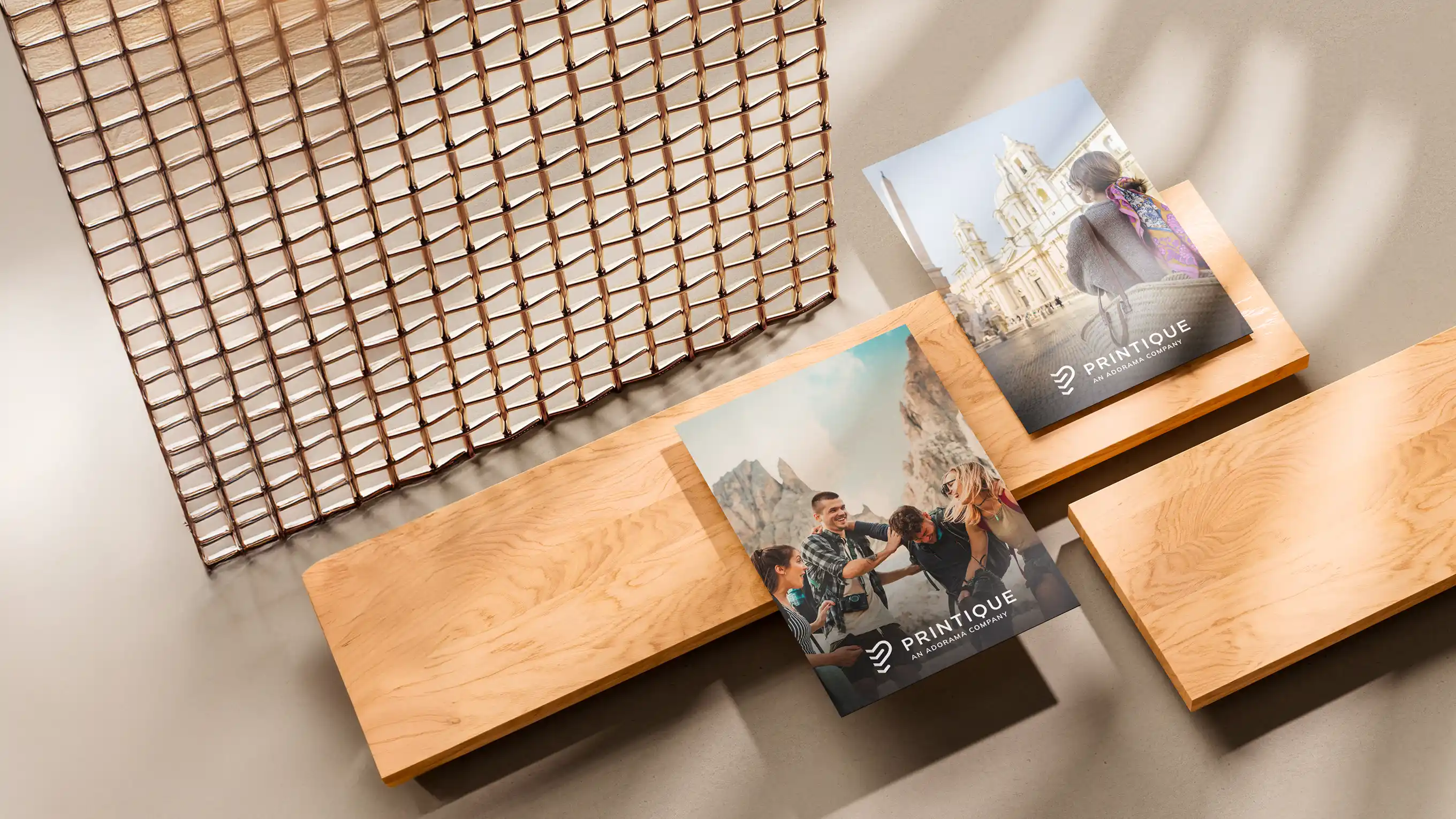 Two photo books on light wooden shelves, one featuring friends hiking and the other showing a woman in front of a historic building, both branded with Printique logo.
