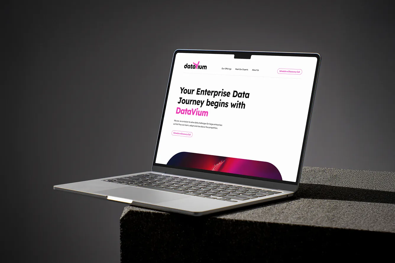 Open laptop displaying DataVium's website with the text 'Your Enterprise Data Journey begins with DataVium' on the screen.