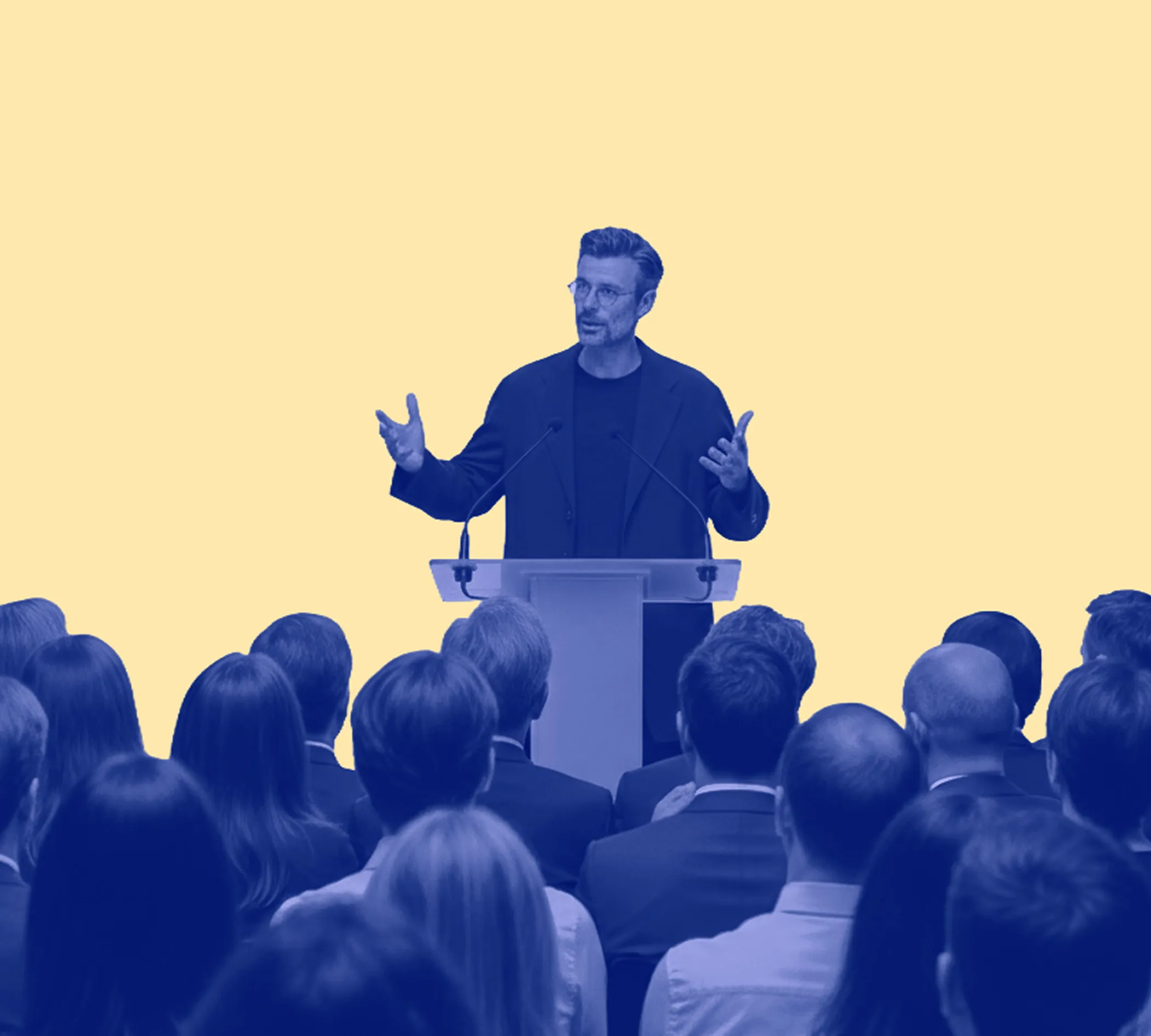 Man giving a speech behind a clear podium to an audience, with a yellow background and blue overlay.