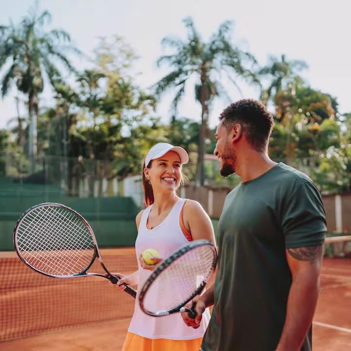 a couple playing tennis at a Swimply rental by the hour at a Swimply tennis court listing