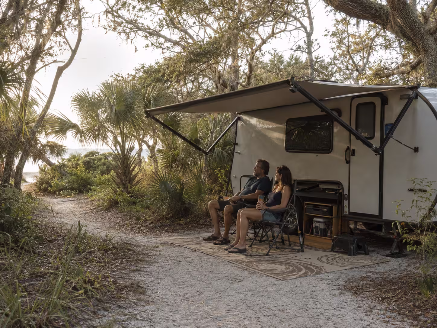 Couple beside a camper rental at a Little Talbot Island campsite near Jacksonville