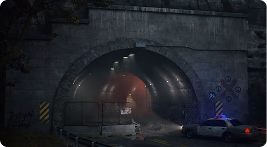 Police car with flashing lights blocking entrance of dimly lit tunnel with chain-link fence and warning signs.