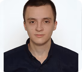 Young man with short dark hair wearing a dark collared shirt against a plain white background.