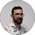 Portrait of a man with a beard and glasses wearing a white shirt with a black pattern.