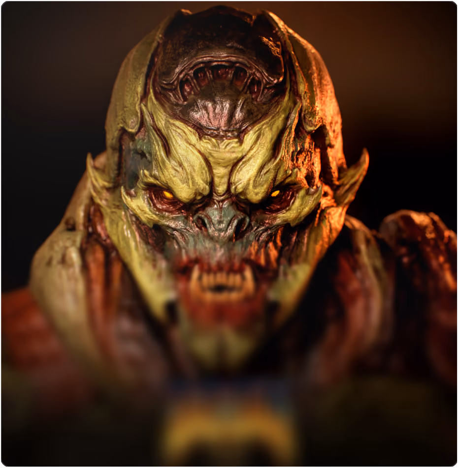 Close-up of a menacing creature with yellow-green, textured skin, glowing orange eyes, sharp features, and an open snarling mouth against a dark background.