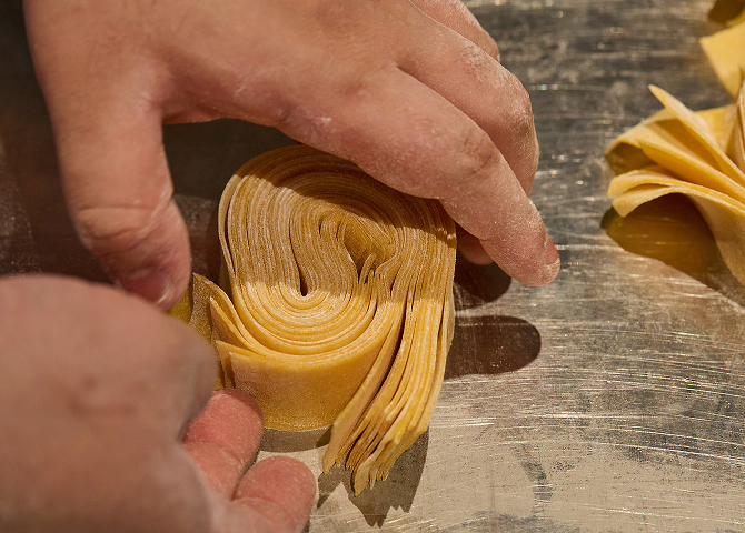 Grilled spiny lobster halved and served with lemon and dipping sauce on a white plate.