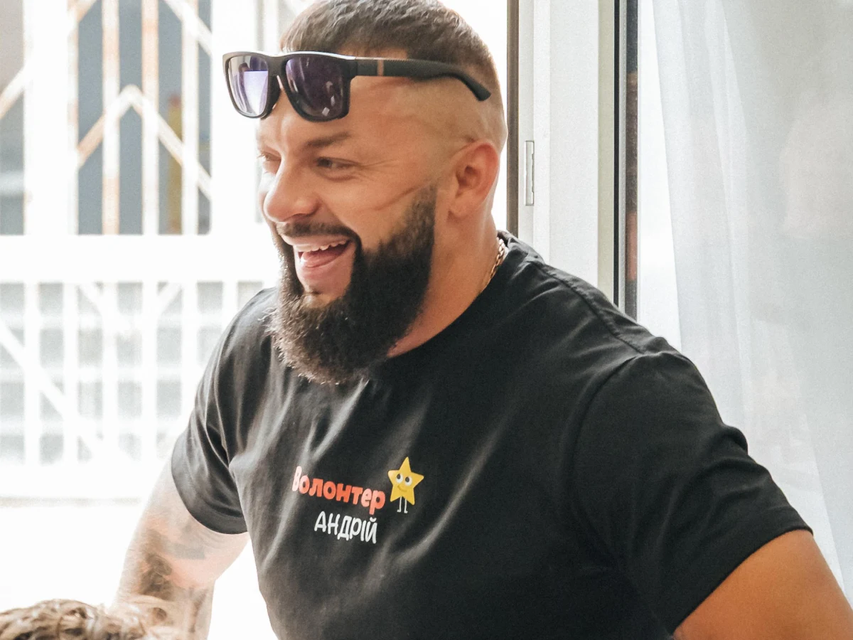 Волонтер фонду Андрій усміхається під час участі в благодійному заході.
