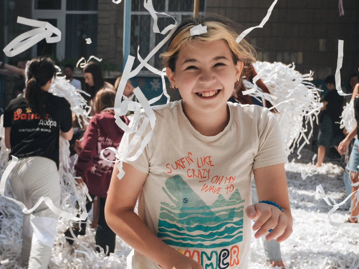 Дівчинка радіє та грається з паперовим конфетті під час дитячого свята.