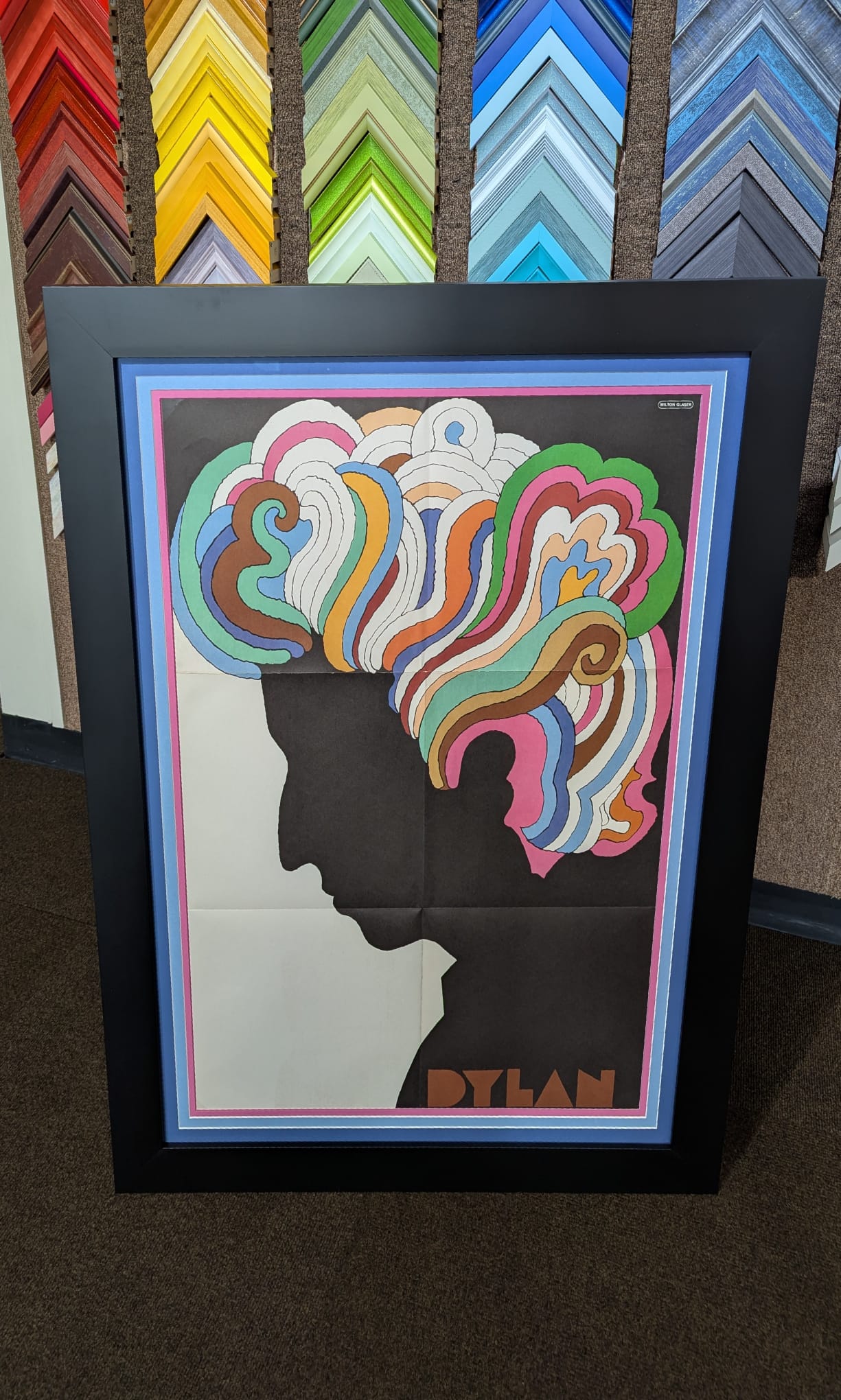 Framed poster of a black silhouette profile with colorful, wavy abstract hair and the word 'DYLAN' at the bottom.