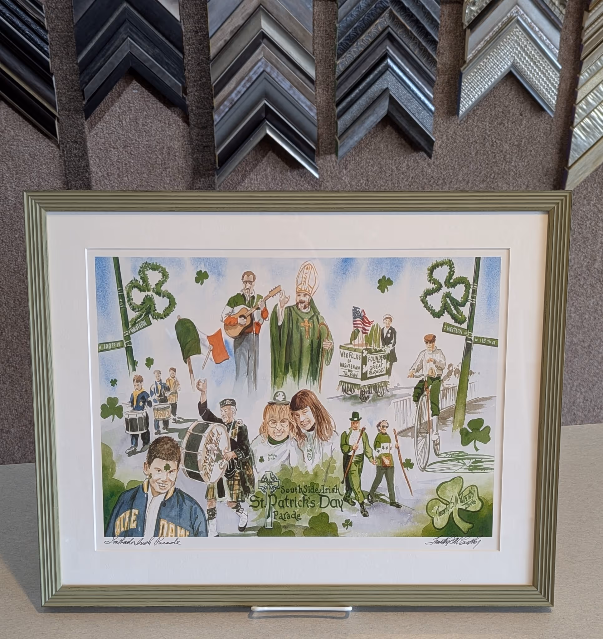 Framed illustration depicting various scenes and characters from the SouthSide Irish St. Patrick's Day Parade, including musicians, children, and parade participants with shamrocks and Irish flags.