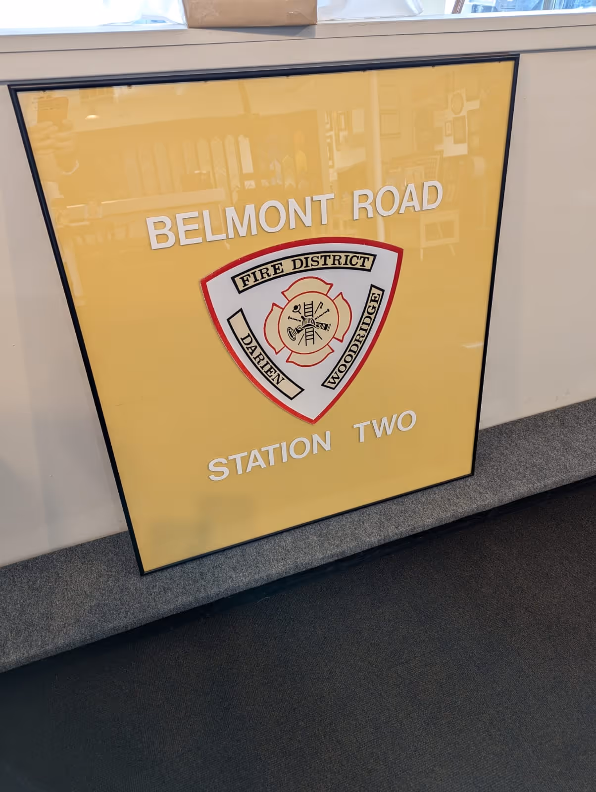 Yellow framed sign with the Darien Woodridge Fire District emblem and the text Belmont Road Station Two.