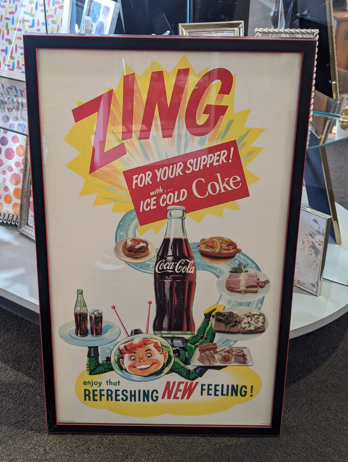 Vintage Coca-Cola ad featuring a large bottle and a smiling boy in a space helmet offering various meals with the text 'ZING for your supper! with ice cold Coke' and 'enjoy that refreshing new feeling!'