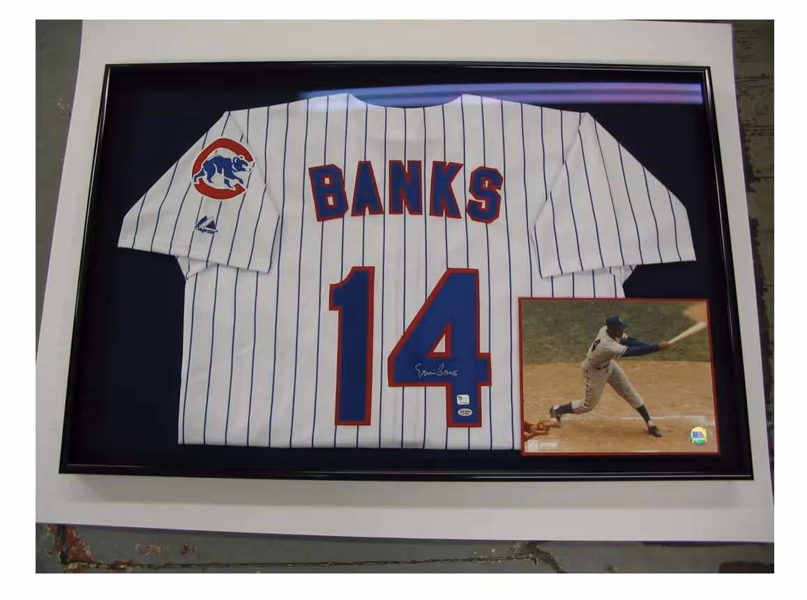 Framed white Chicago Cubs pinstripe baseball jersey with the name 'BANKS' and number 14, signed, with a photo of a player batting.