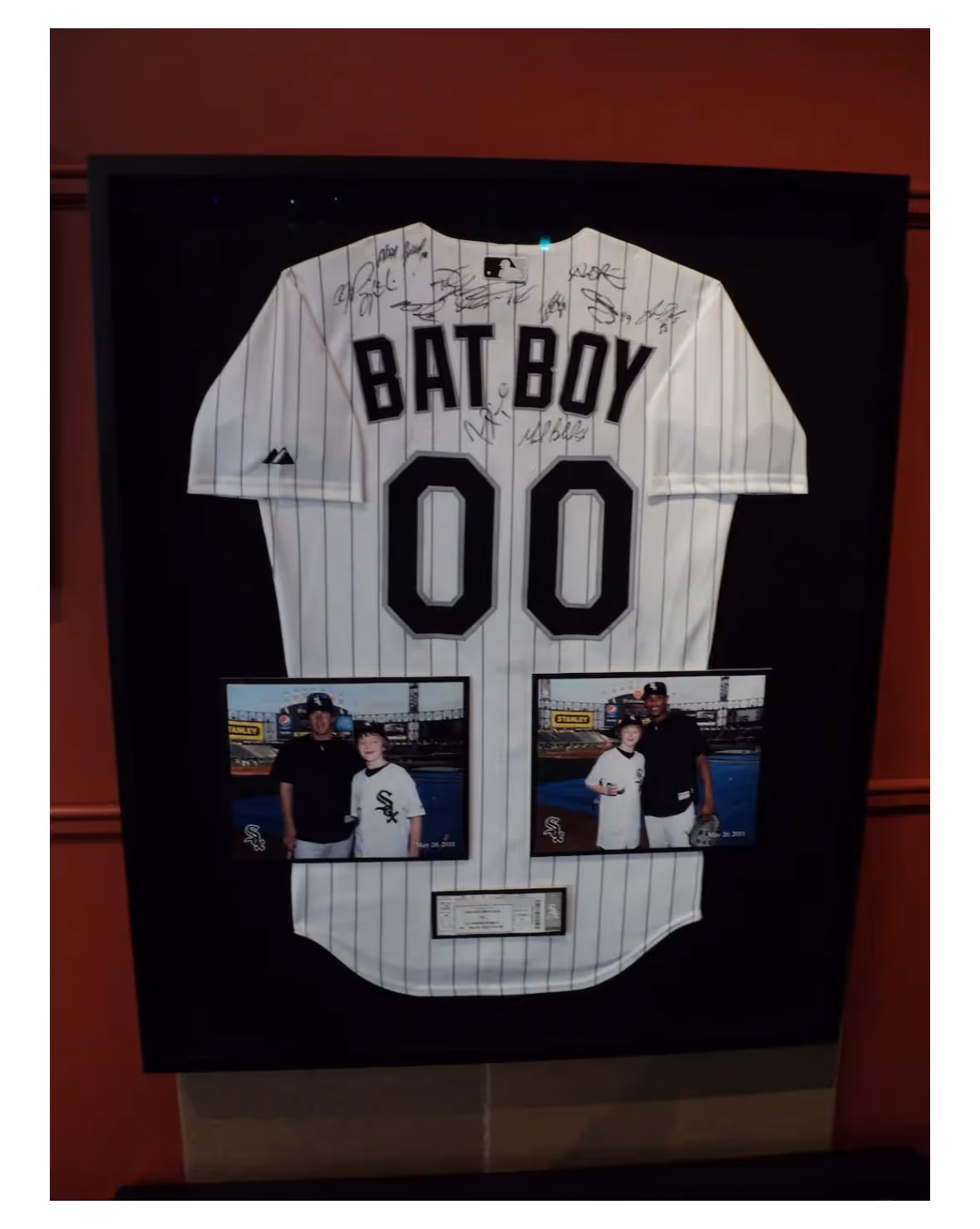 Framed signed Chicago White Sox jersey with "BAT BOY 00" displayed with two photos of a boy posing with players and a ticket stub.