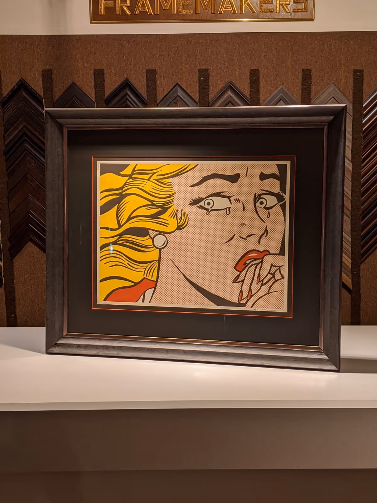 Framed pop art painting of a blonde woman with tears, biting her nails in worry or fear.