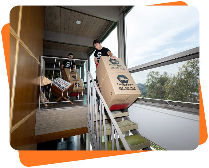 Payable Moving Company movers transporting large moving boxes down a staircase in a modern Los Angeles home