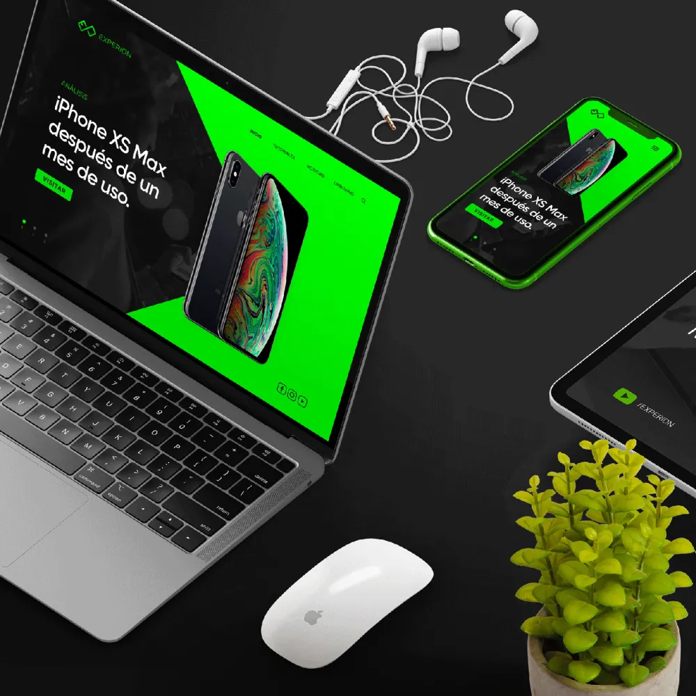 Vista aérea de un escritorio con una laptop y un teléfono mostrando una página web que anuncia un iPhone XS Max tras un mes de uso, acompañados de auriculares blancos, un mouse Apple y una planta pequeña, manteniendo coherencia con el sistema visual. Servicio de branding, ubicación Perú.