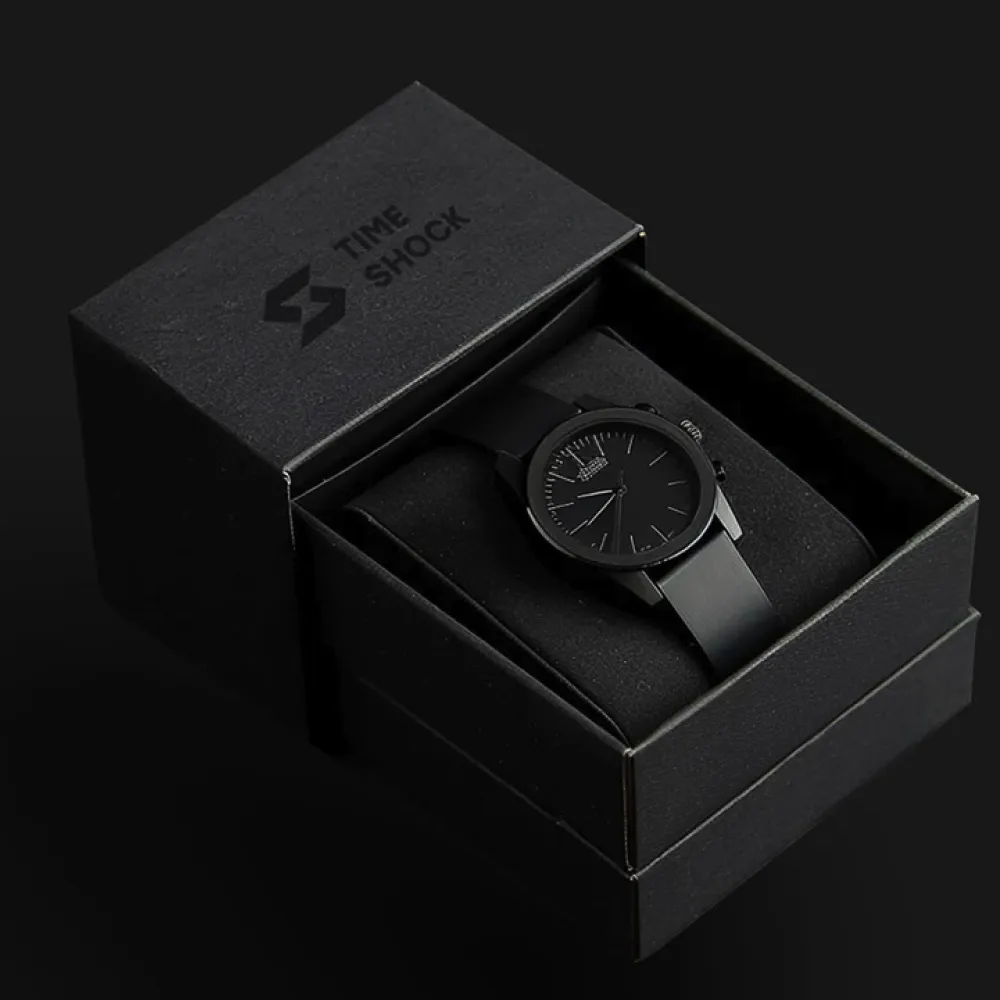 Reloj de pulsera negro con correa y esfera negras, presentado dentro de una caja negra con el logotipo y el texto «TIME SHOCK» sobre la tapa, manteniendo coherencia con el sistema visual. Servicio de branding, ubicación Perú.