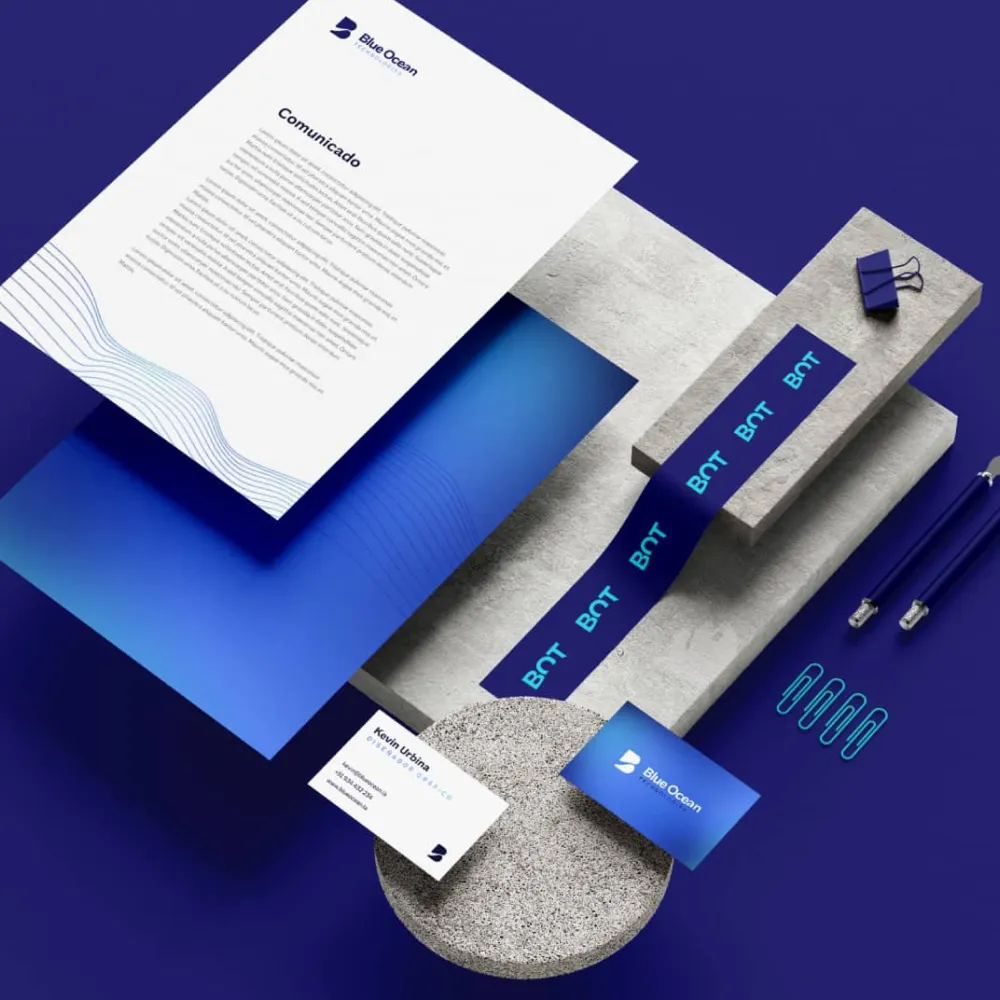 Conjunto de papelería corporativa de Blue Ocean sobre fondo azul, incluyendo hojas membretadas, tarjetas de presentación, bolígrafos, clips y cinta adhesiva con el logotipo, manteniendo coherencia con el sistema visual de la marca. Servicio de branding, ubicación Lima, Perú.