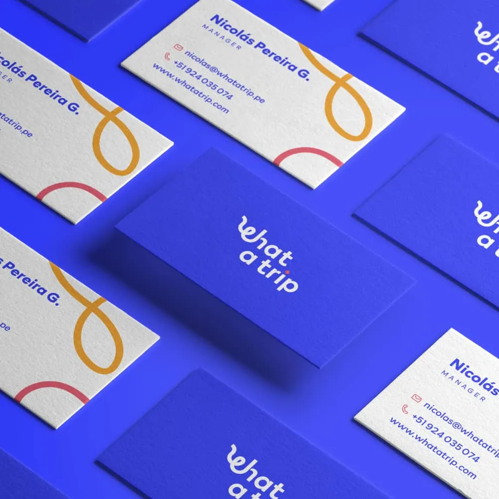 Tarjetas de presentación azules y blancas con el logo y contacto del manager de What a Trip.