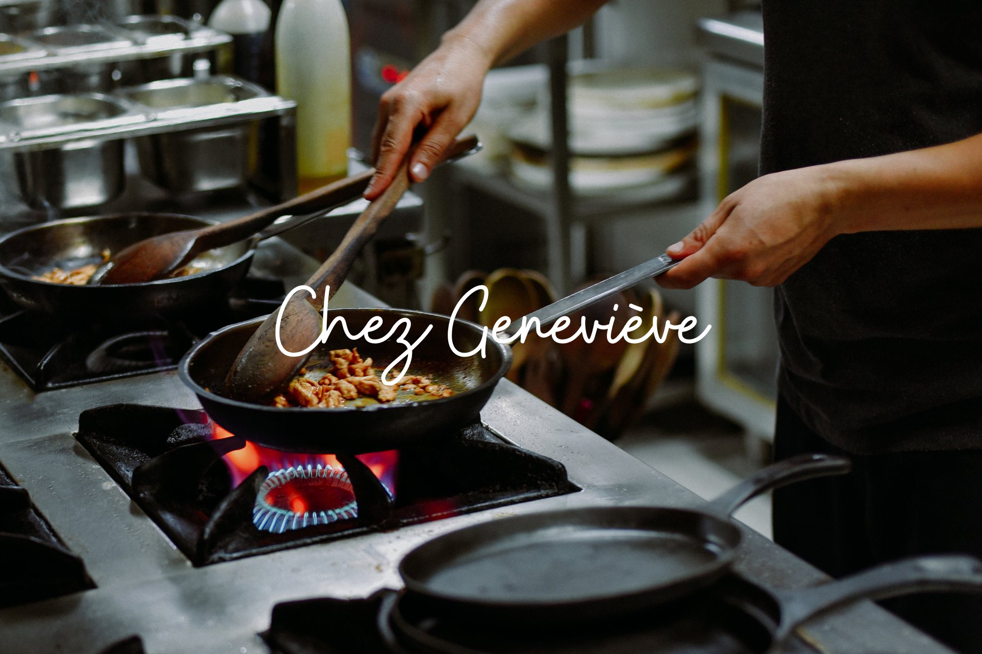 Une personne cuisine des morceaux de viande dans une poêle sur une cuisinière à gaz en flammes dans une cuisine professionnelle.