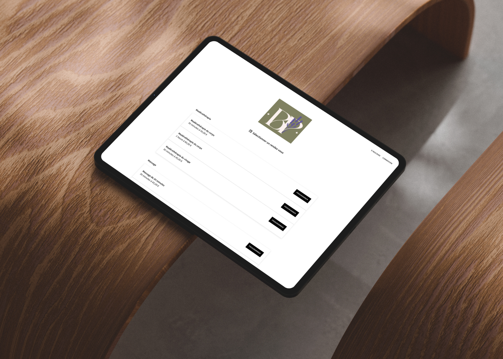 Tablette affichant un site de réservation de soins avec options de maderothérapie et massage avec boutons programmer.