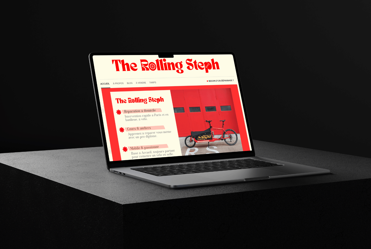 Ordinateur portable affichant le site web de The Rolling Steph avec un vélo devant un mur rouge.