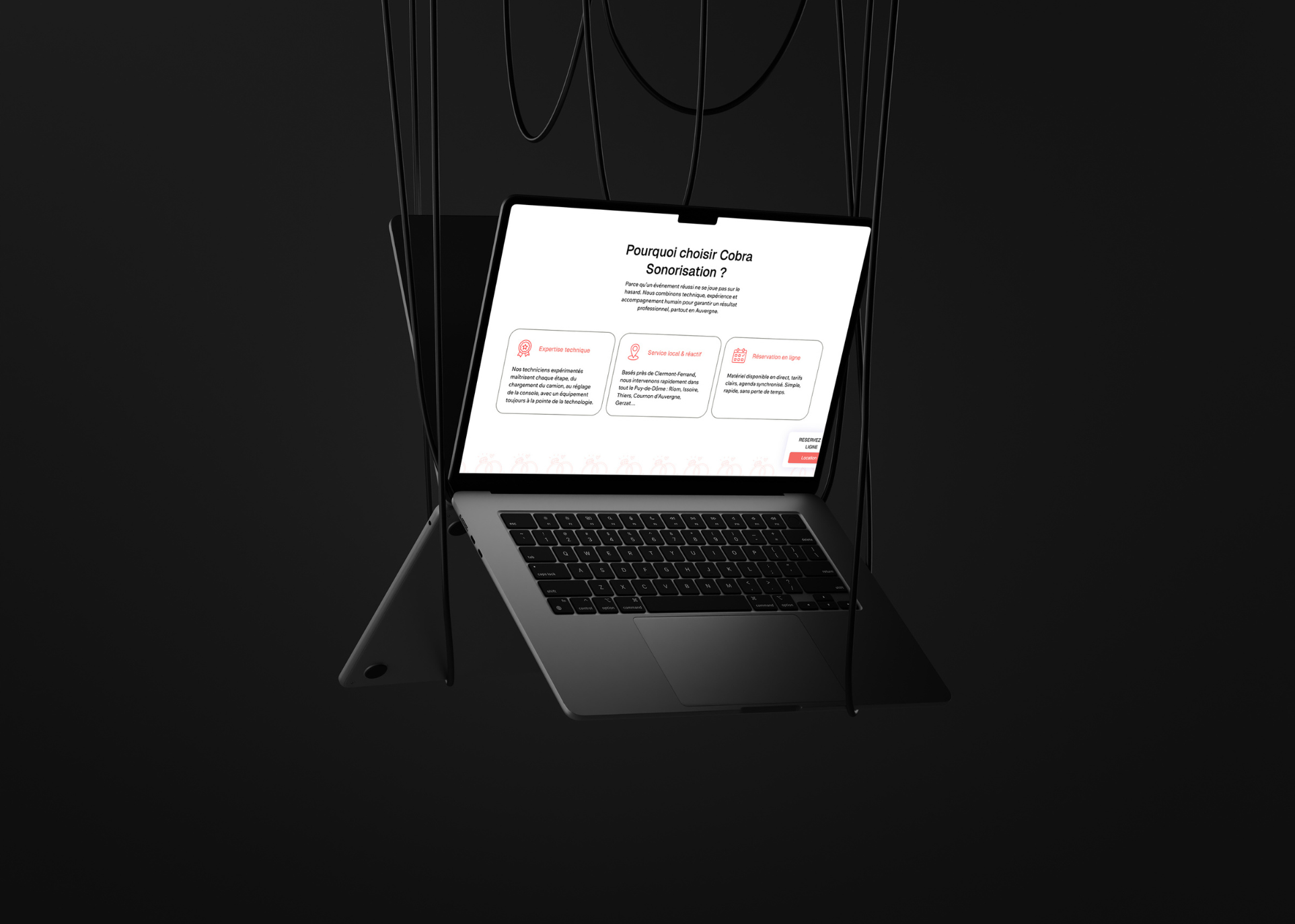 Ordinateur portable suspendu avec un écran affichant une page web sur le choix de Cobra Sonorisation, mentionnant expertise technique, service local réactif, et réservation en ligne.
