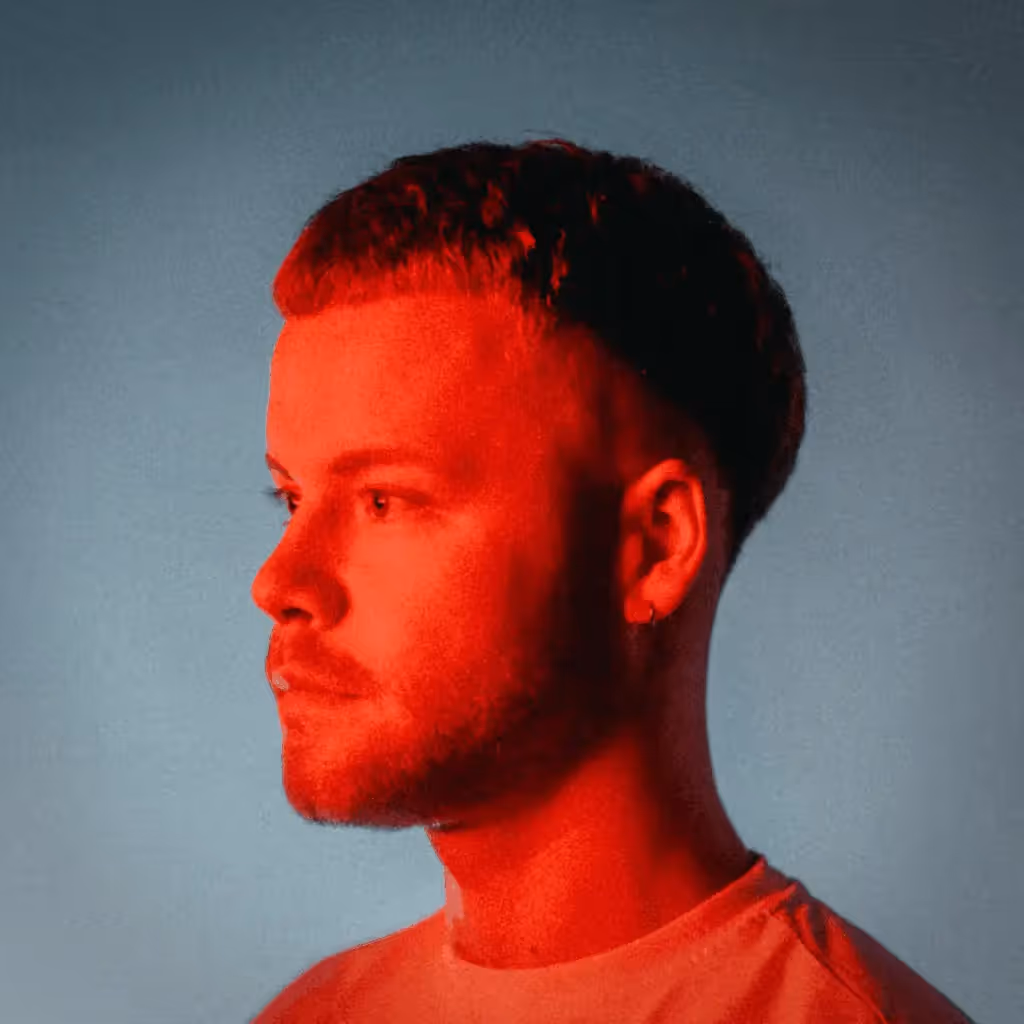 Herr Ulrich Pressefoto. Herr Ulrichs Gesicht ist mit rotem Licht beleuchtet. Er guckt zur Seite.