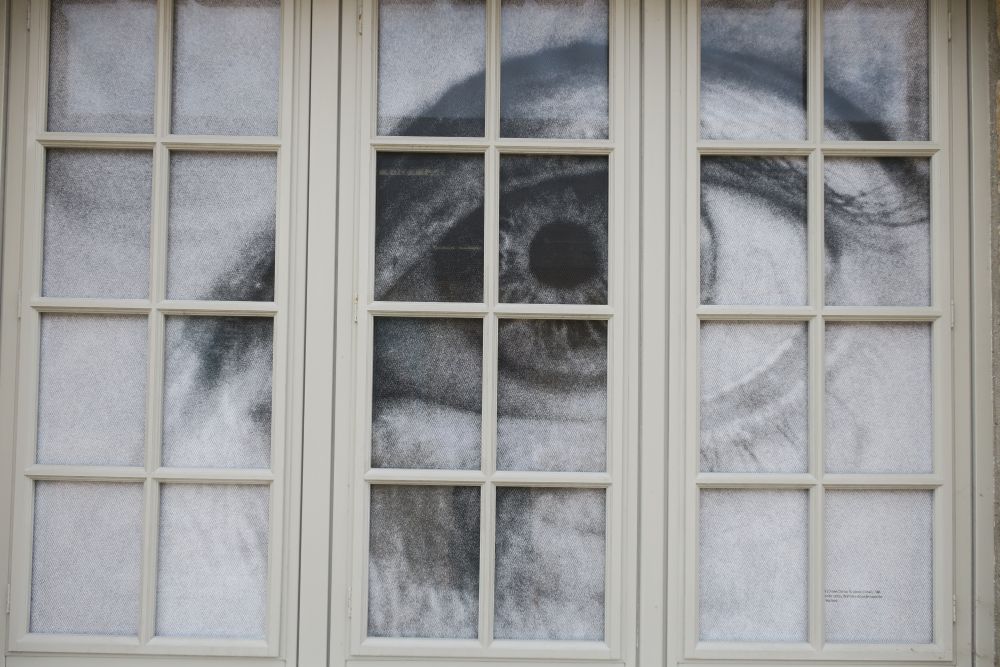 Ein Bild von einem Auge hinter einer Fensterscheibe. 