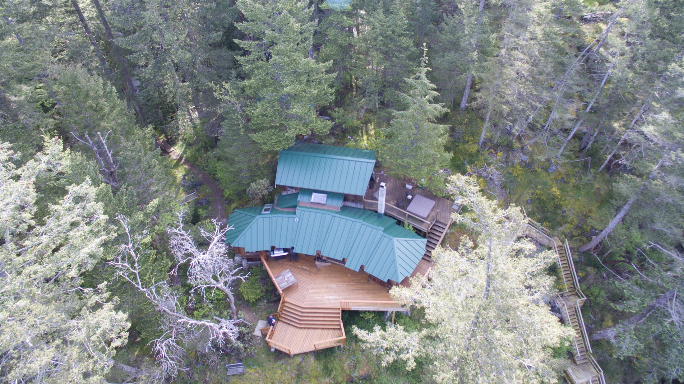 Aerial view of a residential standing-seam metal roof on Vancouver Island showing properly secured panels and ridge detail