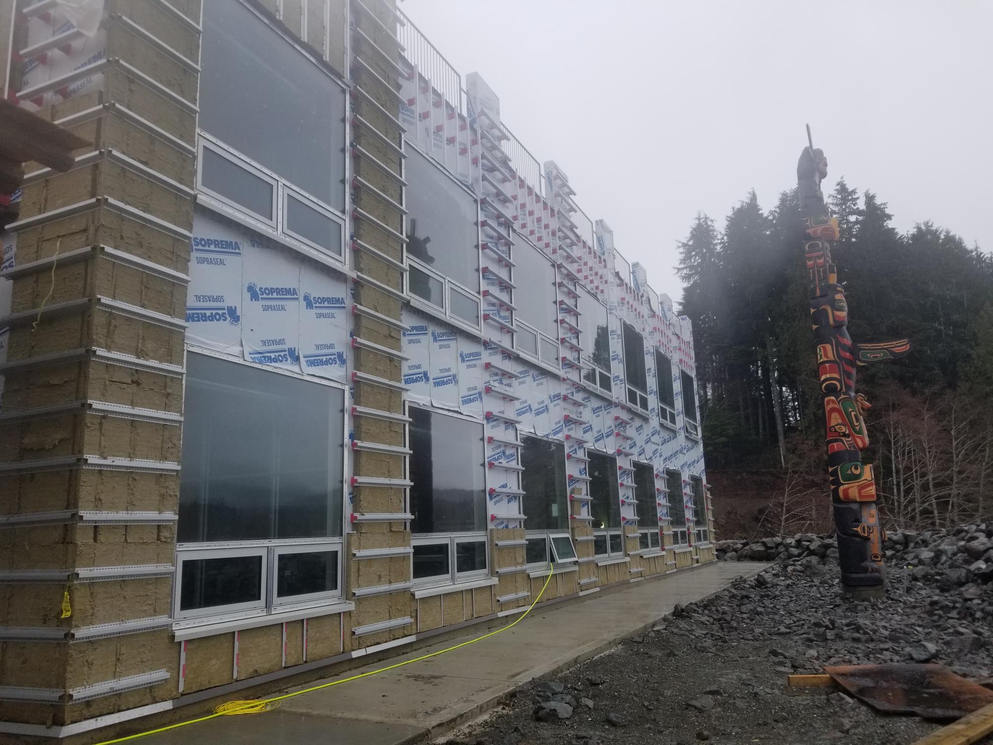 commercial building exterior under construction with mineral wool insulation panels and taped air barrier