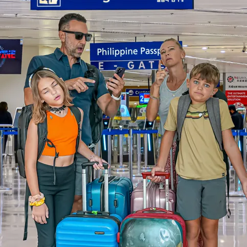 The Lockwood family standing in an airport terminal, looking confused