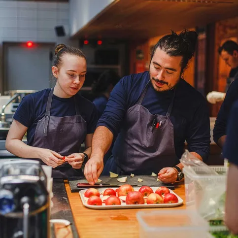 Two chefs working side-by-side in a kitchen