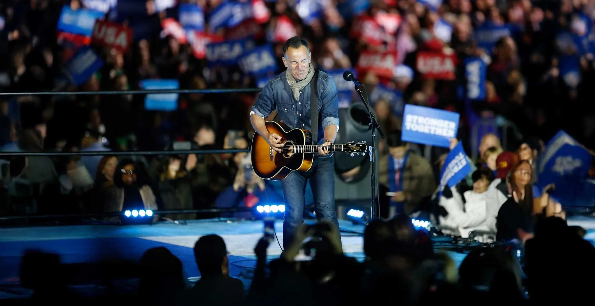 Bruce Springsteen plays guitar for an arena crowd